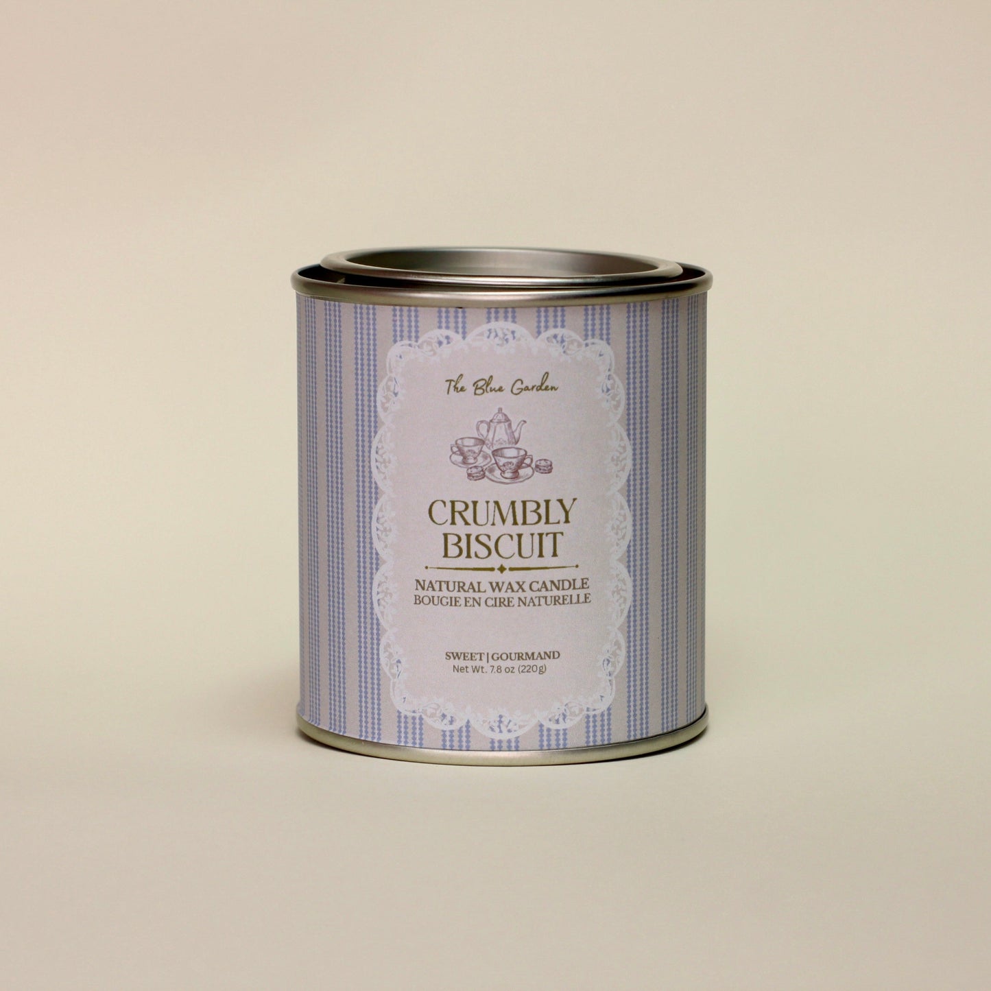 Candle tin labeled 'Crumbly Biscuit' on a beige background