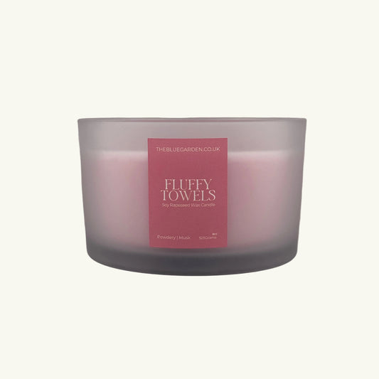 Frosted glass candle with a pink label on a white background
