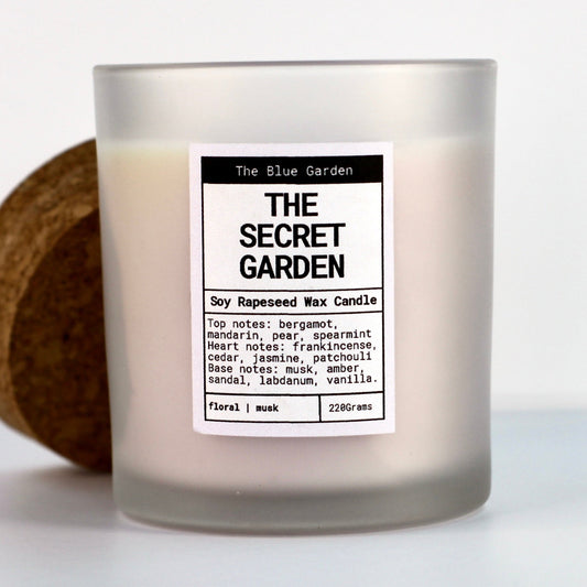 scented soy Candle labeled 'The Secret Garden' from 'The Blue Garden' with a label detailing fragrance notes. hand poured in Yorkshire by the blue garden