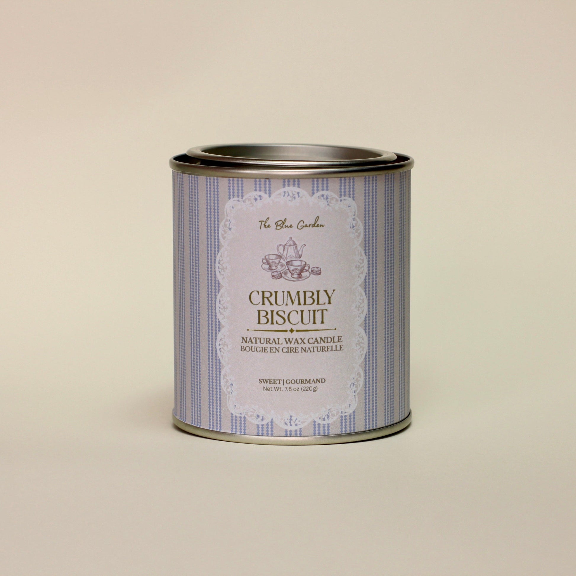 Candle tin labeled 'Crumbly Biscuit' on a beige background