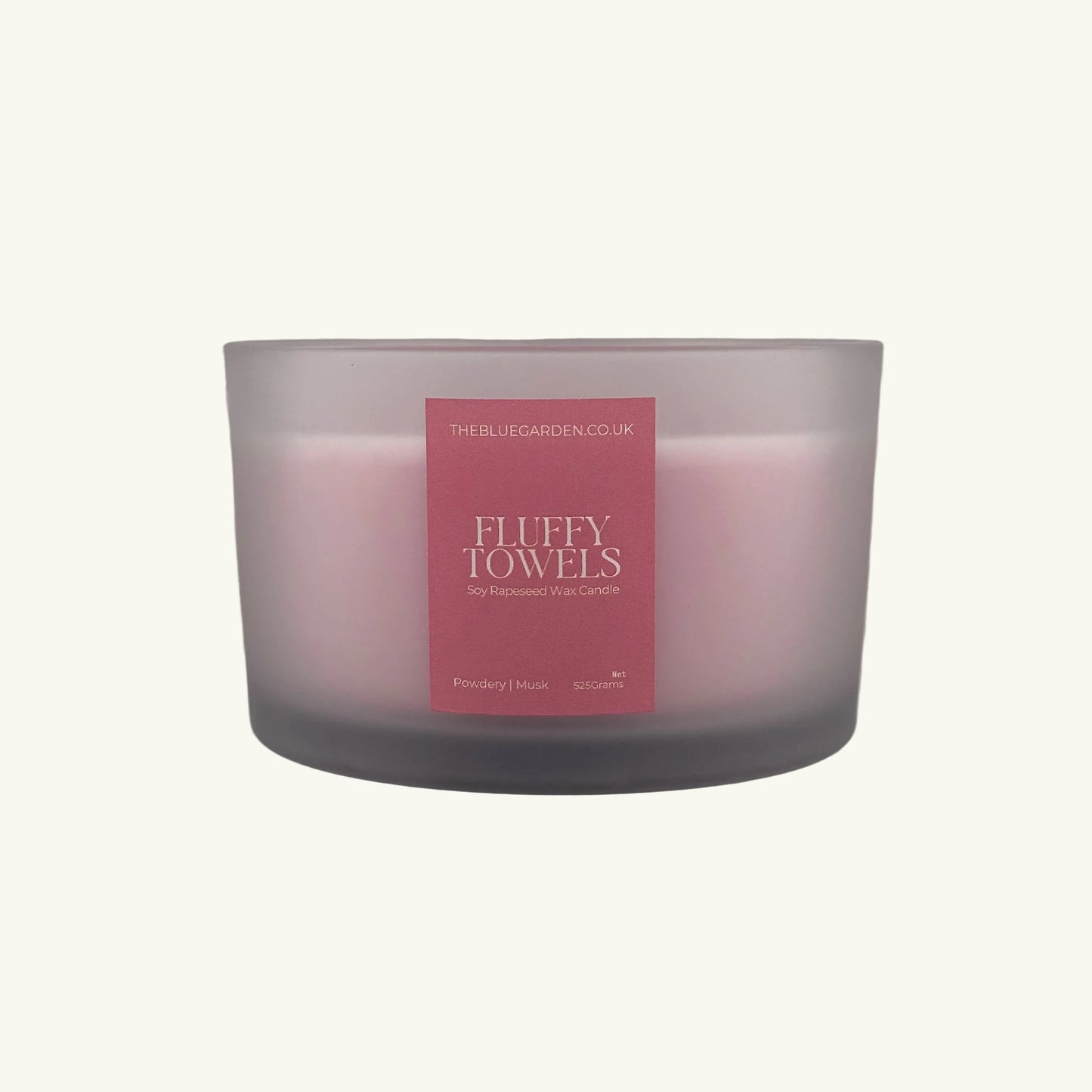 Frosted glass candle with a pink label on a white background