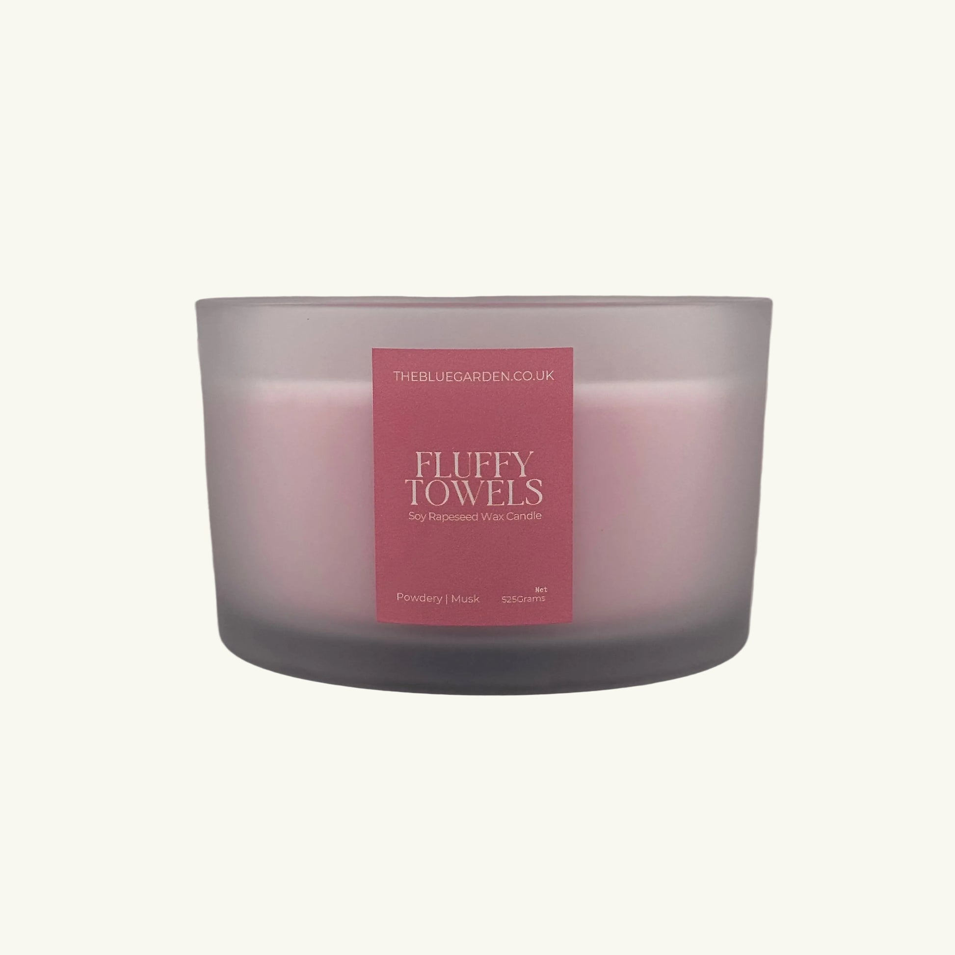 Frosted glass candle with a pink label on a white background