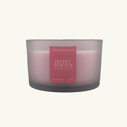 Frosted glass candle with a pink label on a white background