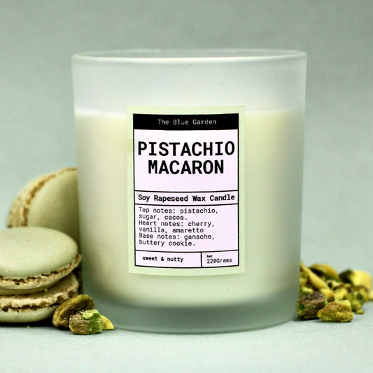 scented soy Candle labeled 'Pistachio Macaron' with macaron cookies on a green background. hand poured in hull by the blue garden