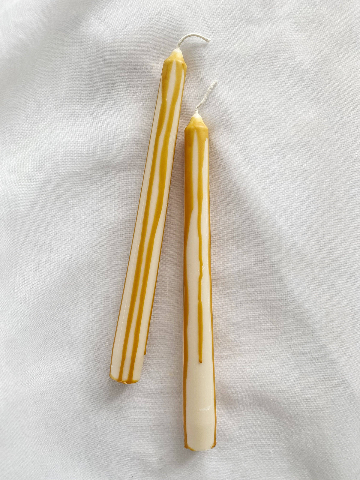 abstract pair of large dinner candles with caramel dripping wax 
