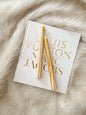 Two gold candles on a Louis Vuitton magazine on a fur surface